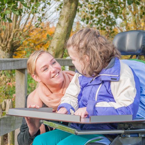 NDIS service provider talking with little girl in wheelchair